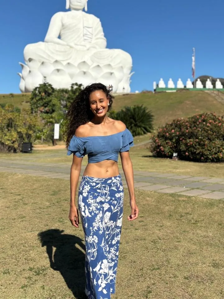 Joelma em frente a uma estátua de Buda