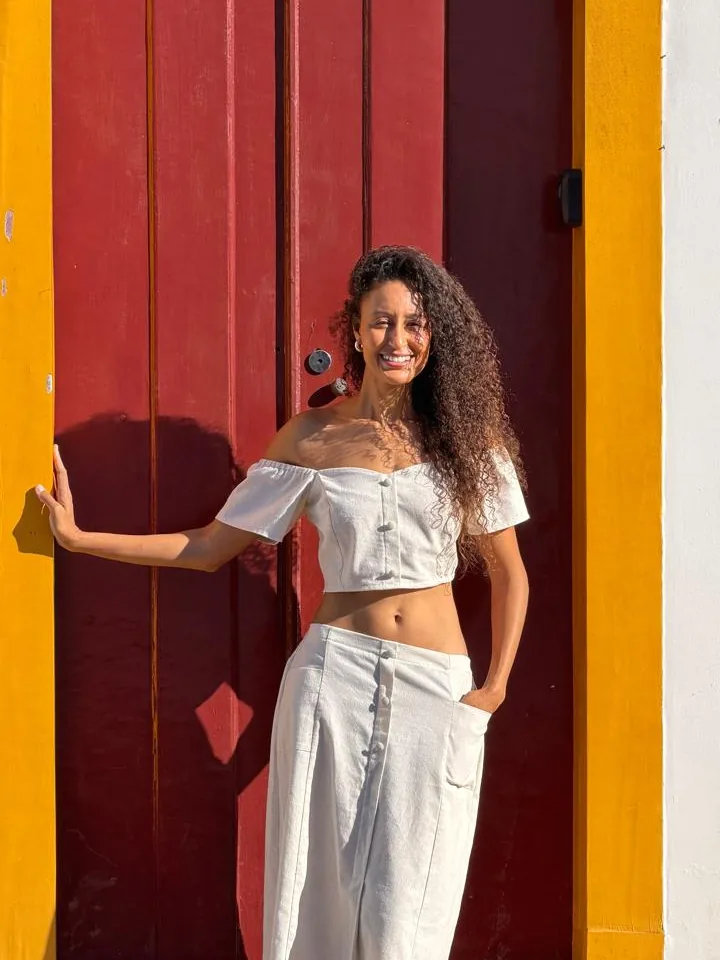 Joelma em frente a uma porta vermelha